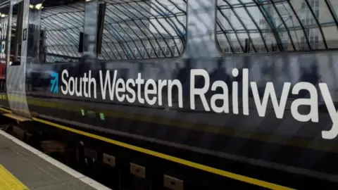PA Media A South Western Railway train on a platform.