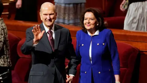 Getty Images President of the Church of Jesus Christ of Latter-Day Saints, Russell M Nelson (L) and his wife Wendy (R) wave to the faithful after the first session of the 189th Annual General conference in the Conference Center on April 6, 2019 in Salt Lake City, Utah