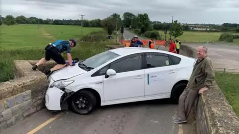Mark Williamson A white Uber car wedged on a 15th Century bridge on the B4085 Honeybourne Road, Bidford-on-Avon