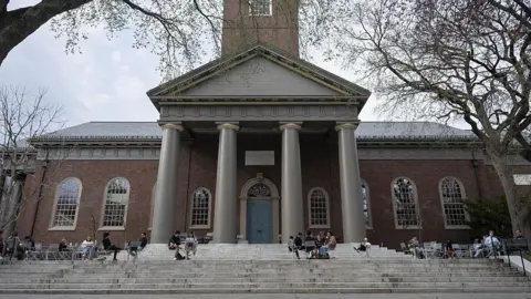 Getty Images Student sit on steps at Harvard outside a large academic brick building